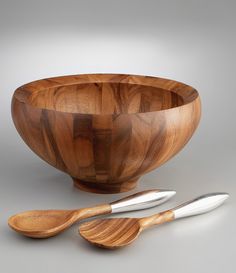 a wooden bowl with two spoons next to it