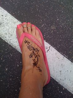 a woman's foot with a tattoo on the side of her leg and pink slippers