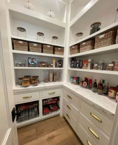 an organized pantry with white cabinets and lots of food in baskets on the top shelves