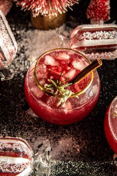 a red drink with ice and garnish in it