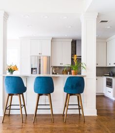 two blue stools sit in front of a kitchen island