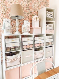 a room filled with lots of boxes and drawers next to a lamp on top of a table