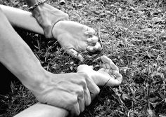 a person sitting in the grass with their bare feet propped up on one leg and another foot resting on the ground