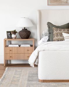 a bedroom with a bed, nightstand and lamp