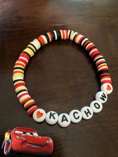 Kachow! Lightning McQueen cars inspired clay bracelet. Clay beads with his signature phrase added. No two color patterns alike since they are handmade.  Ready to ship size is 6 1/2 inches  Please select another size if needed Bracket Patterns Beads, Avengers Clay Bead Bracelet, Cute Clay Bracelets Ideas, Disney Clay Bracelet Ideas, Clay Bead Bracelets With Charms, Clay Bracelet Christmas, Braclet Templates Beads, Lightning Mcqueen Bracelet, Sports Clay Bead Bracelet