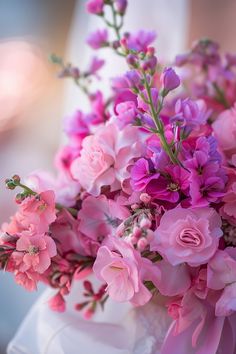 a bouquet of pink flowers in a white vase