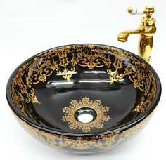 a black and gold sink sitting next to a faucet on top of a white counter