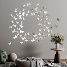 a room with a bed, table and butterflies on the wall hanging from it's sides