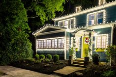 a house is decorated with christmas lights and wreaths