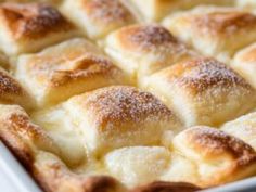 a baking dish filled with rolls covered in powdered sugar