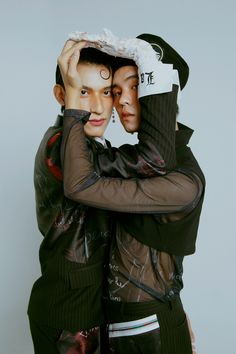 two people are hugging each other with their faces covered by fake hair and makeup on