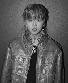 black and white photograph of a woman with piercings on her neck wearing a leather jacket