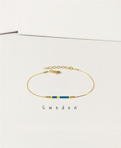 a bracelet with the word sweden written on it and a gold chain attached to it