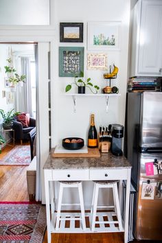 a kitchen with a refrigerator, counter and shelves on the wall