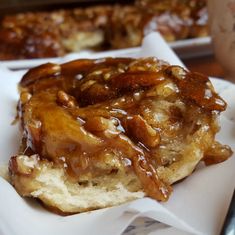 a piece of bread covered in caramel sauce on top of a white paper napkin