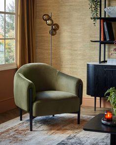 a living room with a chair, table and bookshelf on the wall next to a window