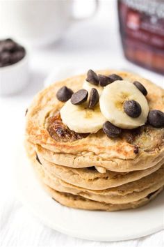 stack of pancakes topped with bananas and chocolate chips