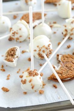 marshmallows and cookies are sitting on top of each other with toothpicks sticking out of them