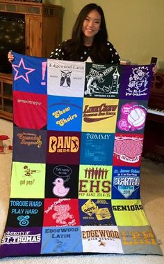 a woman holding up a quilt made from t - shirts