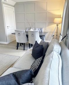 a living room filled with lots of furniture and white walls on the wall behind it