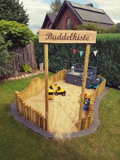 a wooden sign that says buddelliste in front of a small playground area