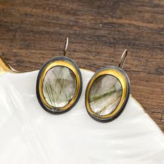 Make a bold statement with these exquisite Prehnite 1.5-inch earrings, elegantly wrapped in 24k gold using the meticulous Korean Keum-boo technique. Each Moss Agate stone showcases unique natural inclusions, making every pair one-of-a-kind. The triangular shape of the stones, paired with the delicate gold wrapping, creates a striking balance of earthy charm and modern sophistication! These earrings are perfect for adding a touch of organic beauty to any outfit, while the 24k gold accents provide a luxurious finish. Lightweight and versatile, they can effortlessly transition from day to night, making them a standout addition to your jewelry collection. Add these Moss Agate earrings to your wardrobe for a timeless yet contemporary look! Keum Boo, Moss Agate Stone, Agate Earrings, Agate Stone, Moss Agate, Organic Beauty, Round Earrings, Ring Bracelet, Gold Accents