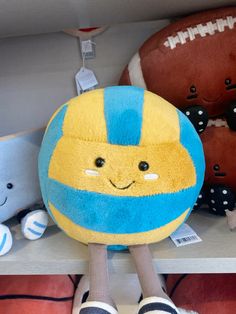 stuffed toys are sitting on shelves in a toy store, one is yellow and the other is blue