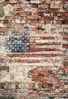 an american flag painted on the side of a brick wall with paint chippings