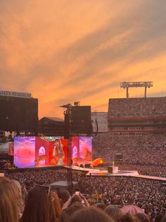 a large crowd at a concert watching the sun set