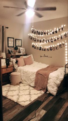 a bedroom with lights strung from the ceiling and pictures on the wall above the bed