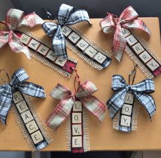 several pieces of scrabble are arranged on a wooden board with ribbon and letters