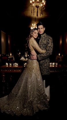 a man and woman standing next to each other in front of a chandelier