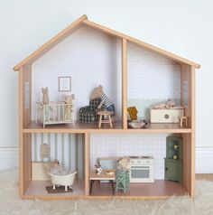 a doll house with furniture and accessories on the floor in front of a white wall