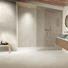 a modern bathroom with white tile and wood accents