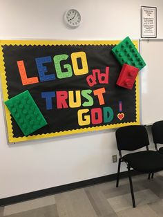 a bulletin board with legos written on it and two chairs in front of it