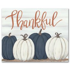 three blue and white pumpkins sitting in front of a wooden sign that says, thank