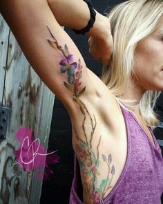 a woman with a flower tattoo on her arm and shoulder is looking at the camera