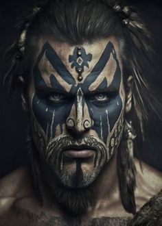 a man with face paint and feathers on his head