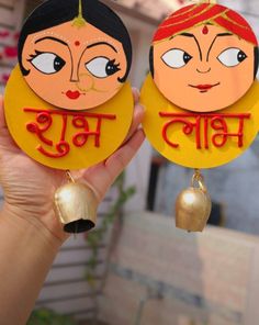 pair of handmade wooden earrings with cartoon faces on them in red and yellow colors