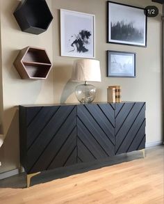 a living room with pictures on the wall and a sideboard in front of it