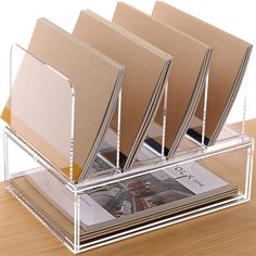 three clear acrylic books in a holder on a wooden table