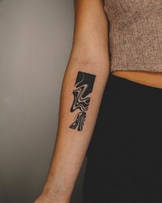 a woman with a black and white tattoo on her arm