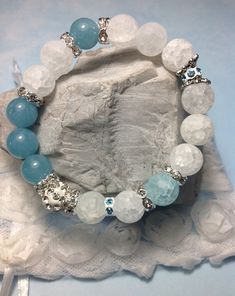 "This Stretch Bracelet You Will Absolutely Love. Made With, 10mm. Matte Crystal, Aqua Blue, Sponge Quartz Stones, White/Silver Rhinestone Clay Ball, Tibetan Silver Flower Bead Caps, Swarovski Crystal Aqua Blue/White Wavy And Silver Plated Wavy Crystal Rondelles. QUARTZ CRYSTAL is known as \"The Stone of Manifesting.\" Is is the most powerful healing, cleanser and amplifying crystal. It is able to store information and used as a programming receptor. This Master healer vibrational connects the ph White Crystal Bracelet As A Gift, White Crystal Bracelets As Gift, White Crystal Bracelet For Gifts, White Crystal Bracelet As Gift, White Crystal Bracelet For Gift, Crystal Bracelets With 8mm Beads, White Crystal Jewelry With 8mm Beads, White Beaded Bracelets With Stones For Gift, Adjustable White Gemstone Crystal Bracelet