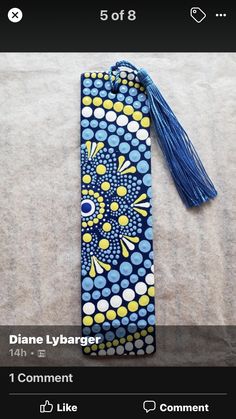 a blue and yellow bookmark with a tassel on it