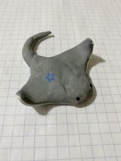 a small gray object with a blue star on it's side sitting on a sheet of paper