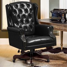 a black leather office chair sitting on top of a wooden desk next to an old typewriter