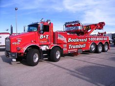 a red tow truck parked in a parking lot