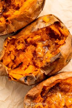 three baked sweet potatoes sitting on top of paper