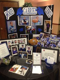 a table topped with pictures and plaques covered in blue ribboned paper on top of a black table cloth