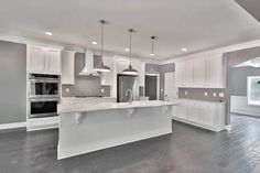 a large kitchen with white cabinets and an island